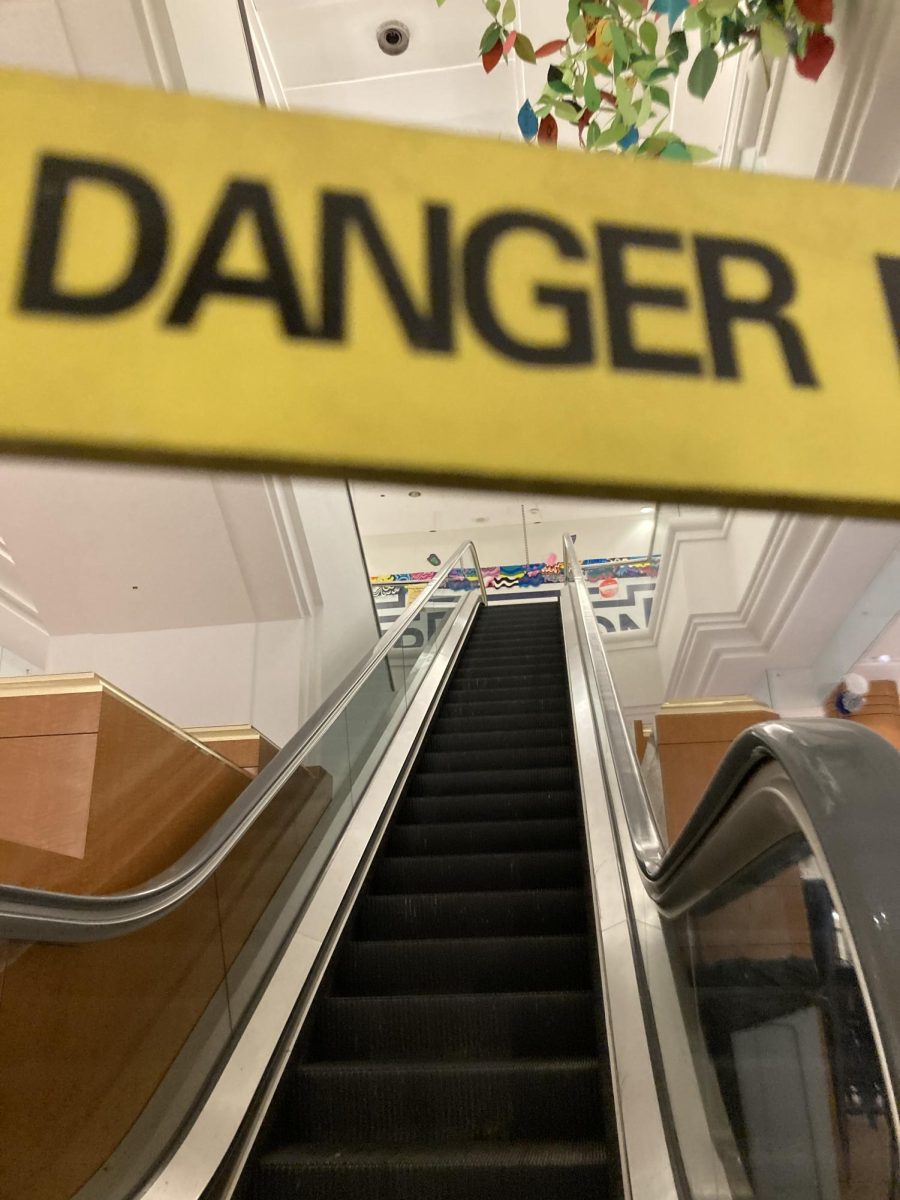 A danger sign in front of the escalators at the former-mall-now-high-school tells students that the escalator is broken.