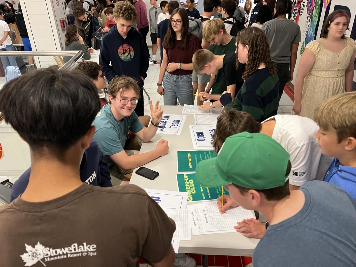 Club Fair 2025: Kyle Buck smiles for the camera while signing students up for the Green-Up Club. 