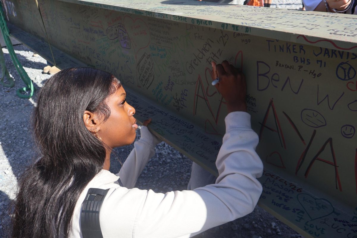 BHS student Anzal Aden signing the beam. 