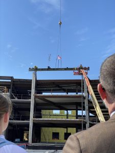 Superintendent Tom Flanagan and a student watch as the final beam for the new high school is put into place. 