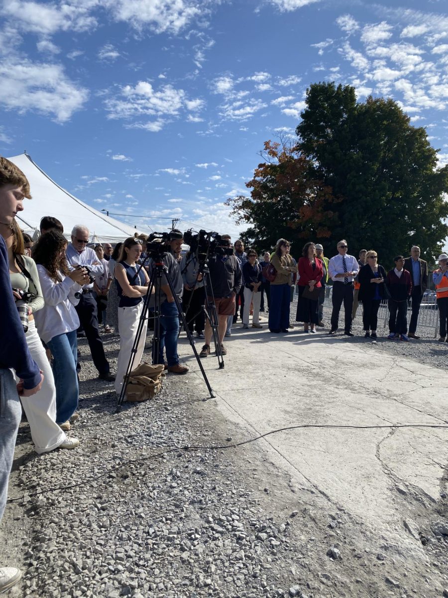 A crowd of community stakeholders and the local media listen to speeches from the major, superintendent, project manager, and others. 