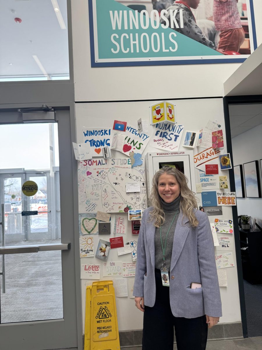 Winooski High School Co-Principal Kate Grodin standing in front of letters of support for the Somali community.