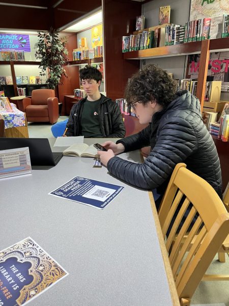 Sean Early 26' hiding his phone while using it in the library.