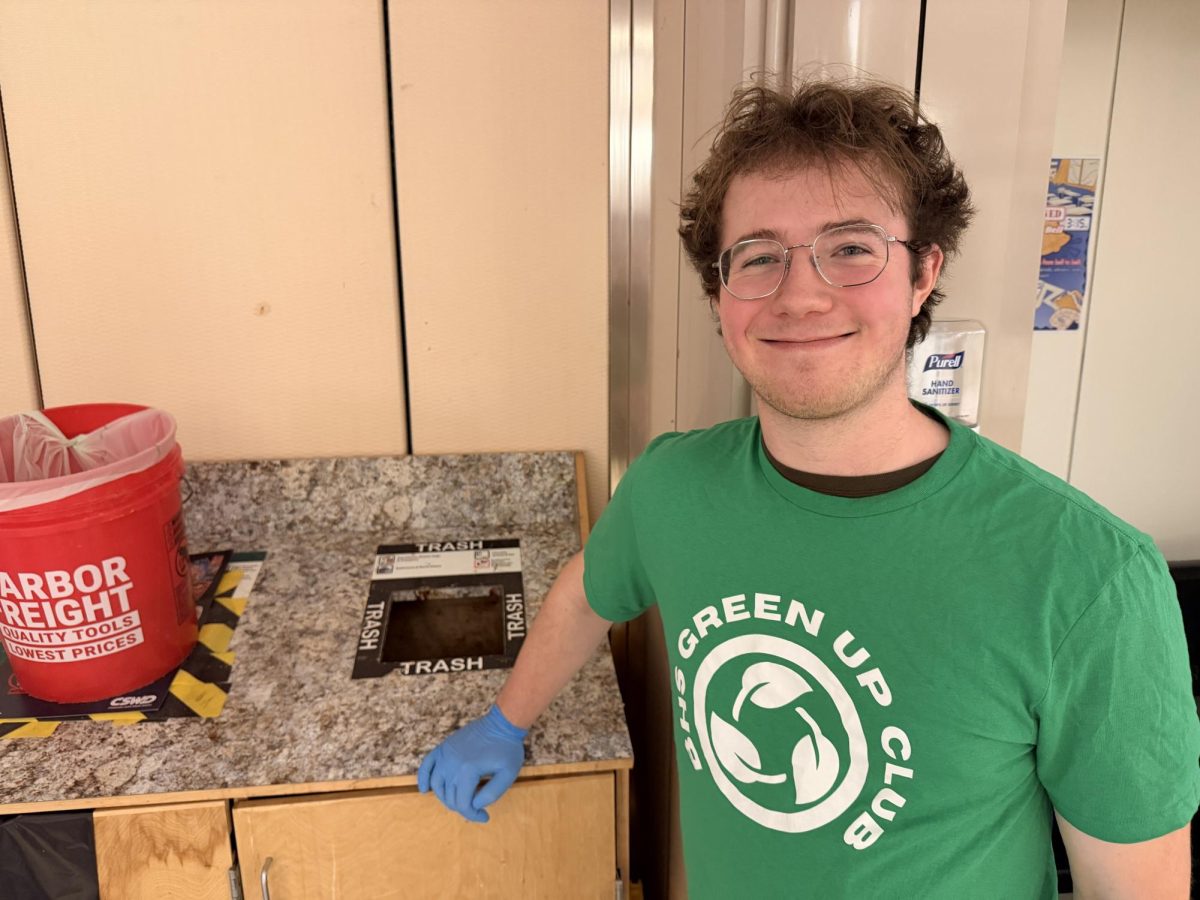 Kyle Buck '26 Co-Founder of the Green Up Club stands by trash can during lunch and reminds students to use the compost. 